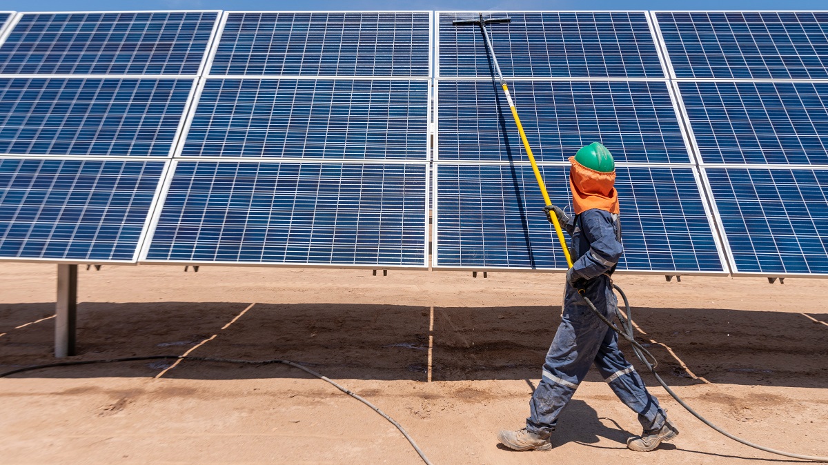 Worker cleaning solar modules in a Solar Energy Power Plant in Atacama Desert at Chile.